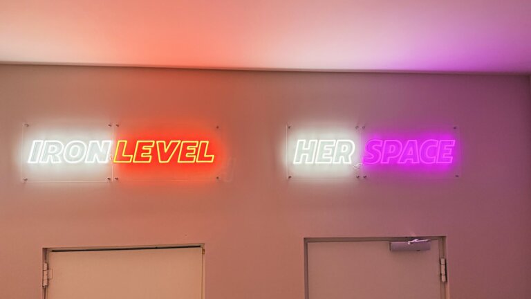 Leuchtschilder Iron Level und Her Space über Kraft- und Frauenbereich